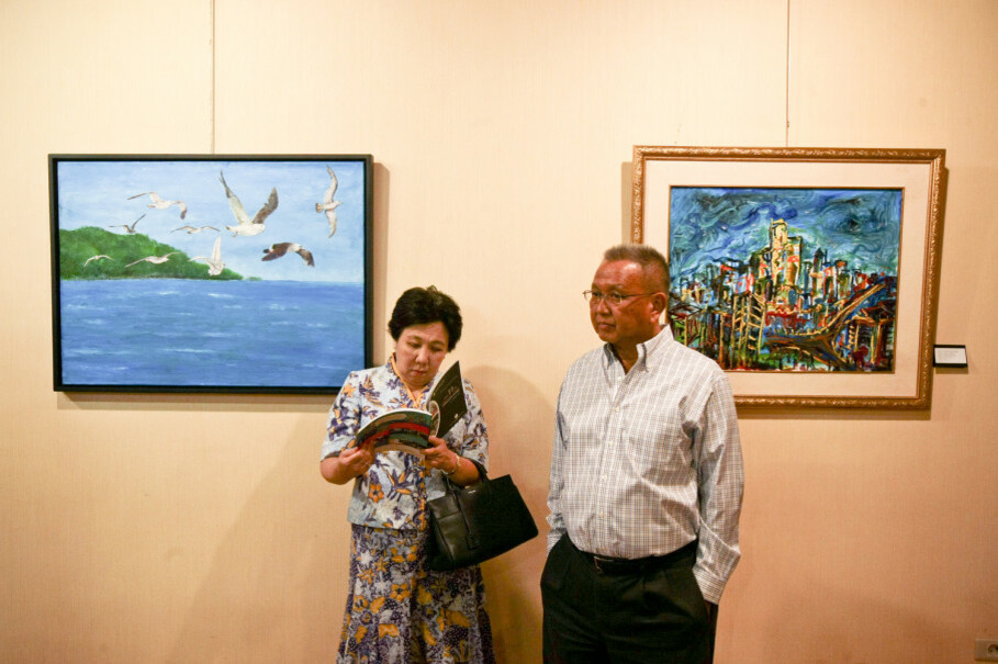 A gallery visitor reads an exhibition catalog next to Japanese artist Kano Taeko's painting. (JG Photo/Yudha Baskoro)