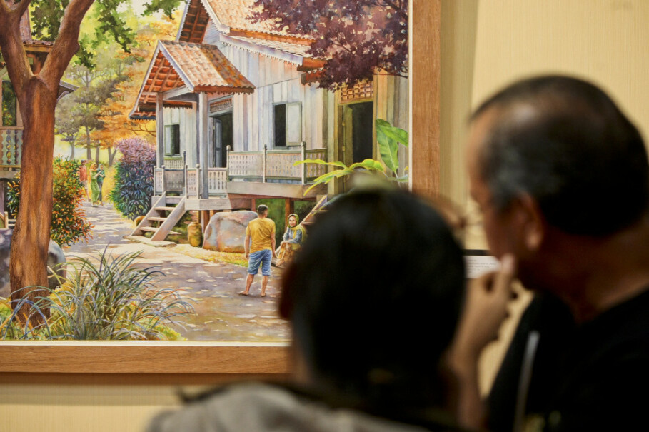 Visitors enjoy Indonesian artist Moelyoto's painting titled, 'Traditional House of Sumatra.' (JG Photo/Yudha Baskoro)