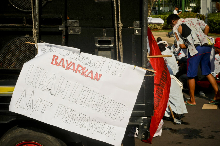 'Jokowi! Give us our overtime pay!' a poster says. (JG Photo/Yudha Baskoro)