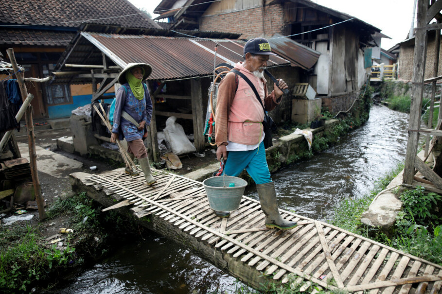 Farmers cross a stream in Tarumajaya village near Lake Cisanti, the main source of the Citarum River, in the mountains south of Bandung. (Reuters Photo/Darren Whiteside)
