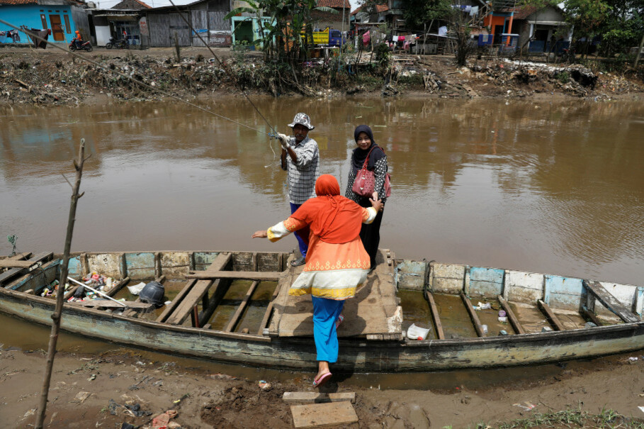 Women board a small boat used as a ferry to cross the Citarum River southeast of Bandung. (Reuters Photo/Darren Whiteside)