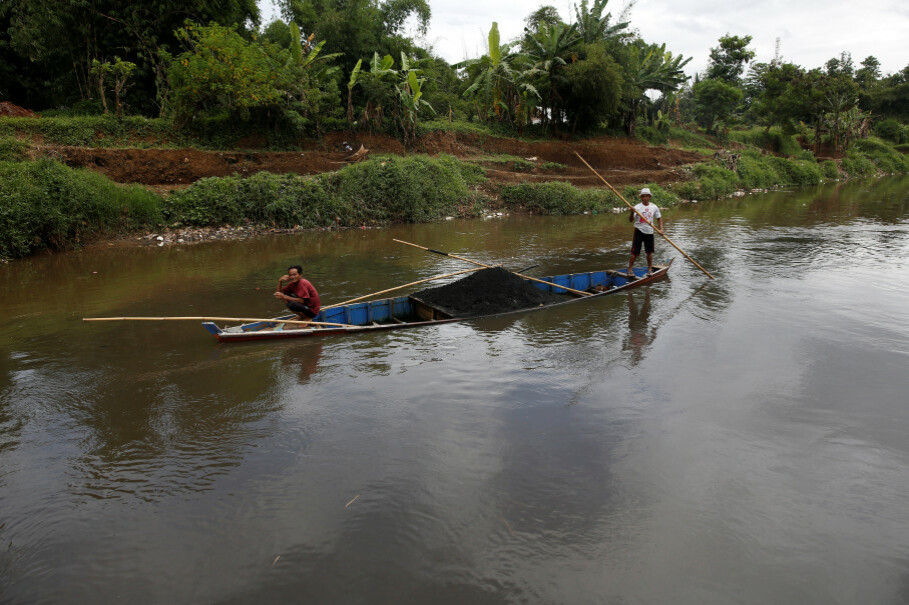 Men guide a boat carrying sand past an area where a section of the Citarum River is joined by a polluted tributary, which runs through an area densely populated with textile factories near Majalaya. (Reuters Photo/Darren Whiteside)