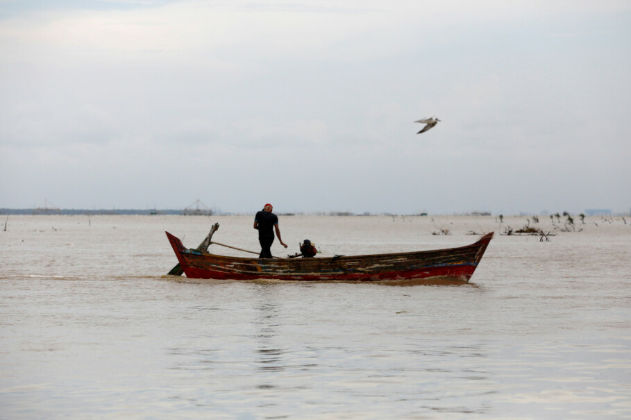 A fisherman operates his boat at the mouth of the Citarum River northwest of Muara Gembong, West Java, on Feb. 22. (Reuters Photo/Darren Whiteside)