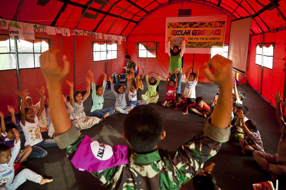 A member of the Indonesian Military leads children in a game designed to help them overcome the trauma associated with the deadly Lombok earthquakes. (JG Photo/Yudha Baskoro)