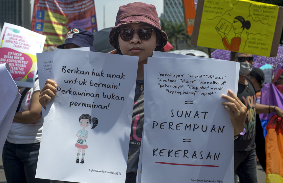 A protestor carries posters stating her disapproval of the practice of child marriage and female genital mutilation. (JG Photo/Yudha Baskoro) 