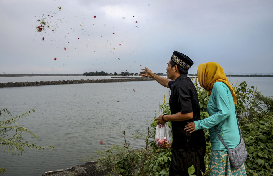 Former Lapindo residents scatter flowers for their deceased families, on the point of embankment 21 Porong, Sidoarjo, East Java on Saturday (04/05). Lapindo victims visit their families and relatives whose tombs had been drowned by mud. ( ANTARA FOTO / Umarul Faruq)