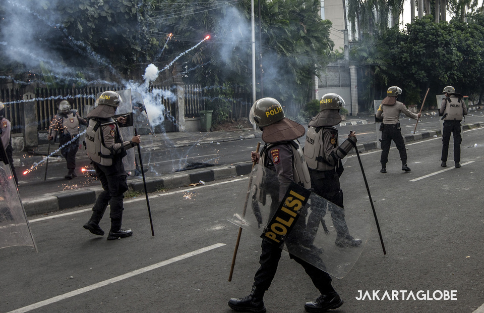 A fireworks explode in front of police officers during the riots in KS Tubun street, Central Jakarta on Wednesday (22/05) (JG Photo/Yudha Baskoro)