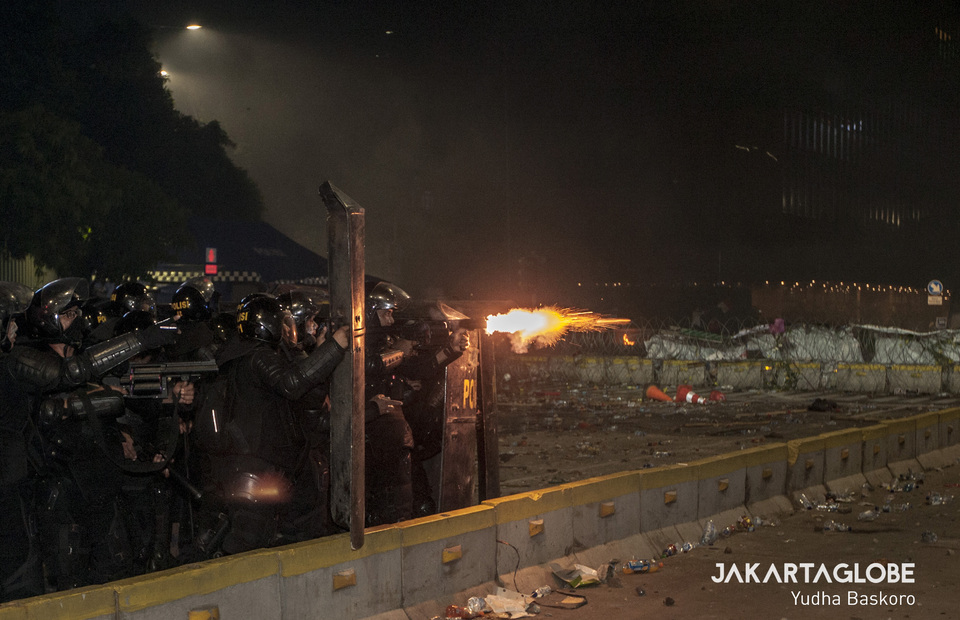 Mobile Brigade personnel shots a flare gun to give a warning to May 22 riot protesters in Thamrin, Central Jakarta on Wednesday (22/05) (JG Photo/Yudha Baskoro)