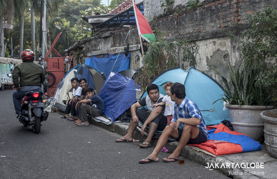 Refugees sit in front of their tent to protect their belongings because their tent is lack of security in Jalan Kebon Sirih, Central Jakarta on Tuesday (18/09) (JG Photo/Yudha Baskoro)