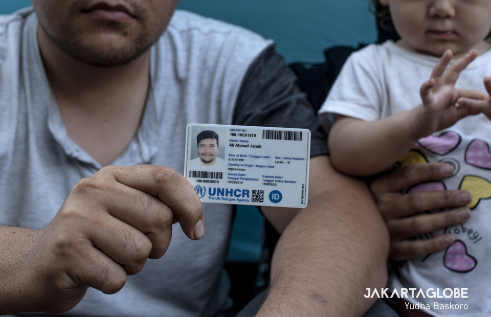 Ali Ahmad Jamili (24) a refugee from Maidan Wardak, Afghanistan shows his UNHCR identity card on Tuesday (18/06) (JG Photo/Yudha Baskoro)