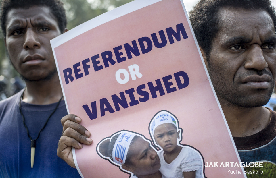 An activist holds up a placard demanding an independence referendum from West Papua. (JG Photo/Yudha Baskoro) 