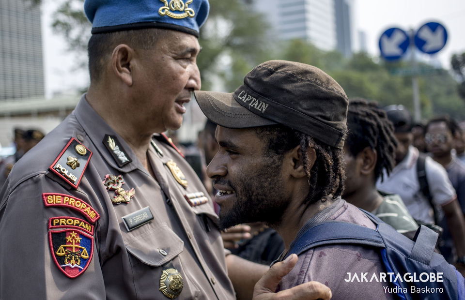 A police officer prevents a protester from approaching the US Embassy. (JG Photo/Yudha Baskoro) 