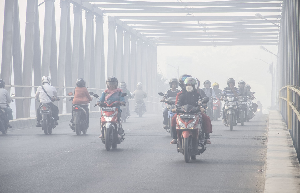 Motorist wear masks when crossing the Pangeran Hidayatullah Street which is shrouded in haze at Banjarmasin, South Kalimantan on Thursday (12/09). (Antara Photo/Bayu Pratama S)