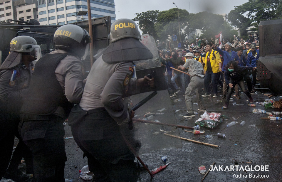 Riot police clash with protesters, some of them armed with bamboo sticks, stones and plastic bottles. (JG Photo/Yudha Baskoro) 
