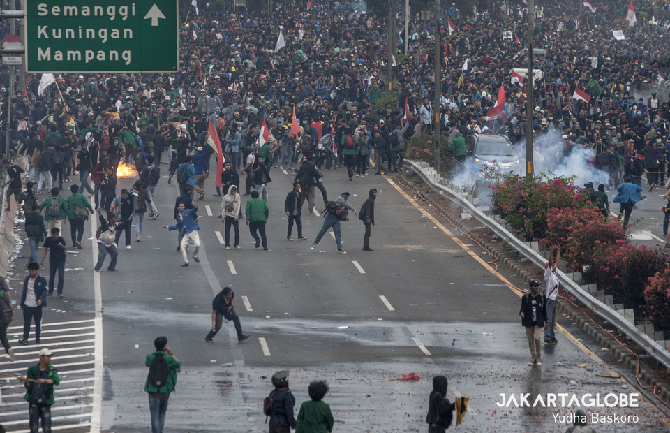 Protestors retreat towards the Semanggi interchange after police used water cannons and tear gas to disperse them. (JG Photo/Yudha Baskoro) 