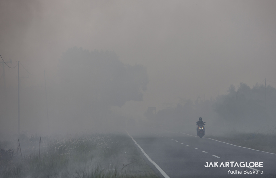 A motorist passes through a smoke and haze in Katingan, Central Kalimantan on Tuesday (01/10). (JG Photo/Yudha Baskoro)
