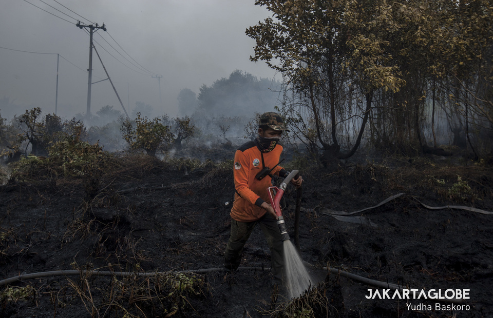 National Disaster Mitigation Agency (BNPB) personnel extinguishes the fire on burned peatland and forest in Katingan, Central Kalimantan on Tuesday (01/10). (JG Photo/Yudha Baskoro)