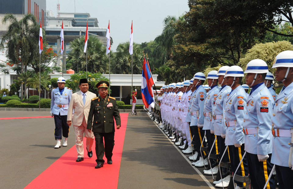 Indonesian Defense Minister Prabowo Subianto, left, accompanied his Lao counterpart Maj. Gen. 