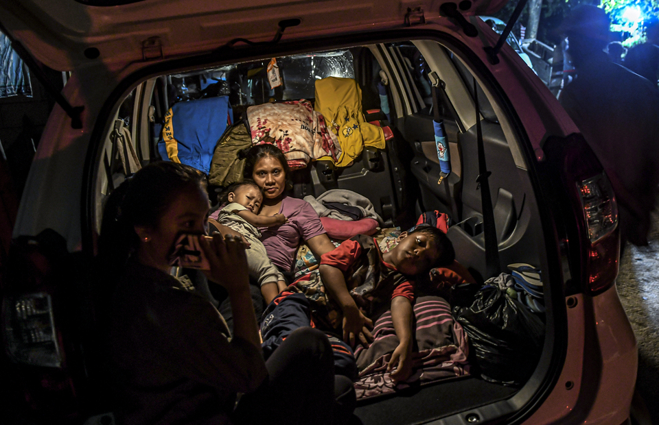 Resident make their car as makeshift shelter during flood at Kampung Baru, Kembangan, West Jakarta on Thursday (02/01) (Antara Photo/Muhammad Adimaja)
