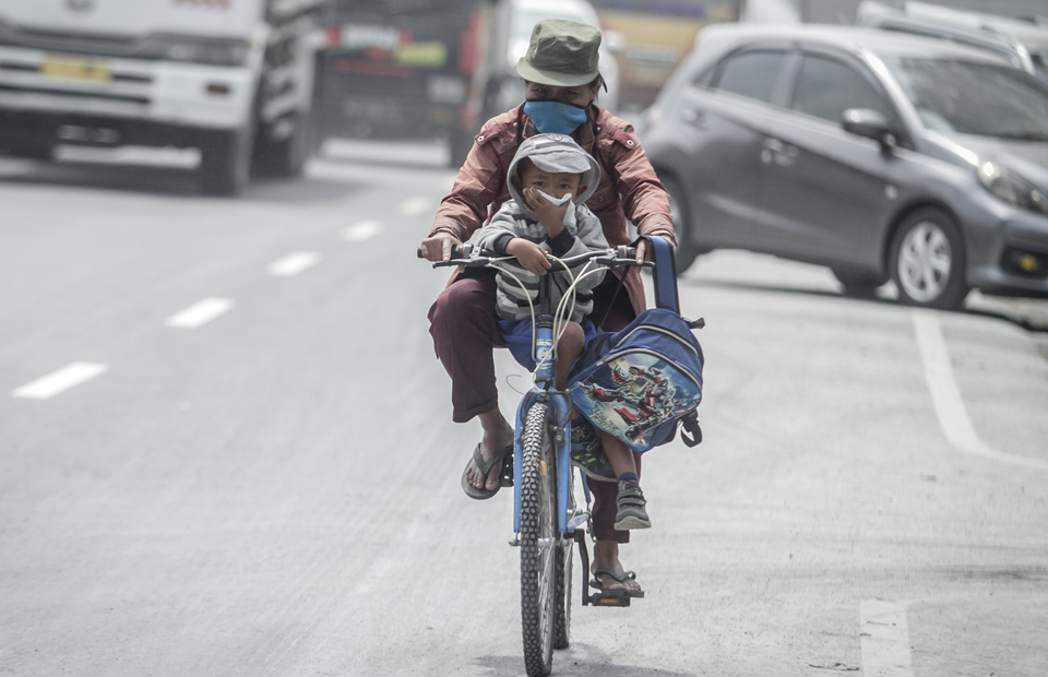 Residents ride a bicycle through mount merapi vulcanic ashes in Kartasura, Sukoharjo, Central Java on Tuesday (03/03). (Antara Photo/Mohammad Ayudha)