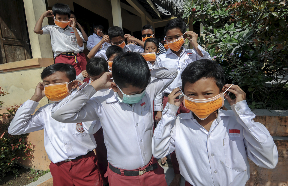 Elementary school students wear mask from Boyolali Regional Disaster Mitigation Agency (BPBD) after Mount Merapi eruption on Tuesday (03/03). Antara Photo/Aloysius Jarot Nugroho)