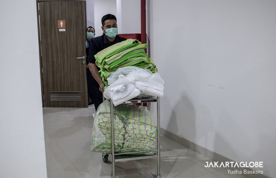 A worker carries a pile of blanket at makeshift COVID-19 hospital in Lippo Plaza Mampang. (JG Photo/Yudha Baskoro)