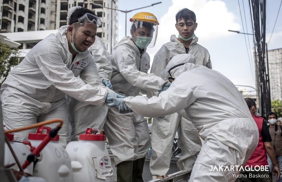 Red cross personnels help their friends get on the car in front of Rusun Benhil II in Central Jakarta on Saturday (04/04). (JG Photo/Yudha Baskoro)