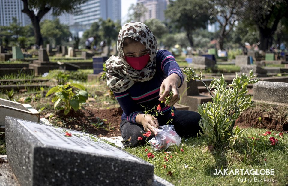 A woman prays at a Karet Tengsin public cemetery in Central Jakarta on Wednesday (22/04). (JG Photo/Yudha Baskoro)