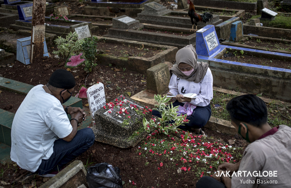 A family prays together at Karet Tengsin public cemetery in Central Jakarta on Wednesday (22/04). (JG Photo/Yudha Baskoro)