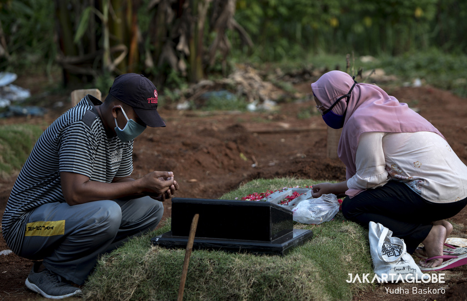 Worshipers prays at graves of their loved ones in Pondok Ranggon public cemetery, East Jakarta, on Wednesday (22/04). (JG Photo/Yudha Baskoro)