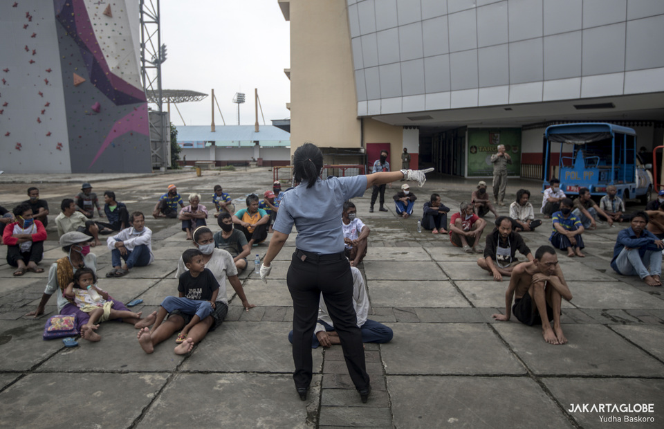 Authority leads the homeless as they sunbathe outside Ciracas sport hall in East Jakarta on Friday (01/05). (JG Photo/Yudha Baskoro)