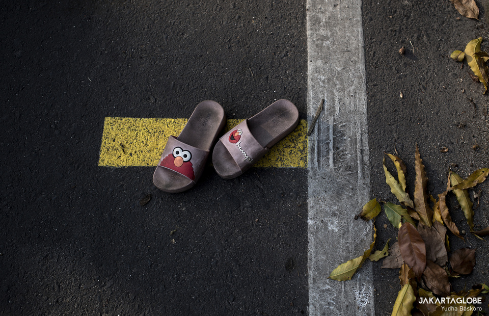 A flip-flops is seen on a yellow physical distancing line. (JG Photo/Yudha Baskoro)