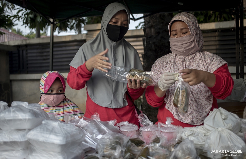Two woman are preparing free takjil packages. (JG Photo/Yudha Baskoro)