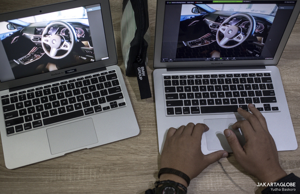 A photojournalist takes screen capture on his laptop during the all-new BMW X6 launching ceremony . (JG Photo/Yudha Baskoro)