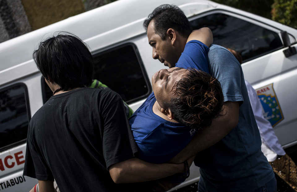 Two man carry a fire victim during fire in Manggarai, South Jakarta on Tuesday (07/07). (JG Photo/Yudha Baskoro)