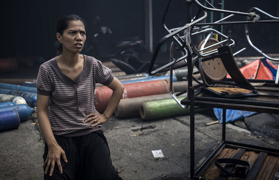 Yuni, 40, sits near her belongings during fire in Manggarai, South Jakarta on Tuesday (07/07) She has been living at her parents in laws inheritance Surya Baru restaurant which is built on the 70s. (JG Photo/Yudha Baskoro)