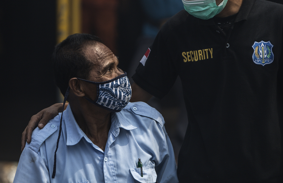 A security guard calms down a fire victim during fire in Manggarai, South Jakarta on Tuesday (07/07). (JG Photo/Yudha Baskoro)