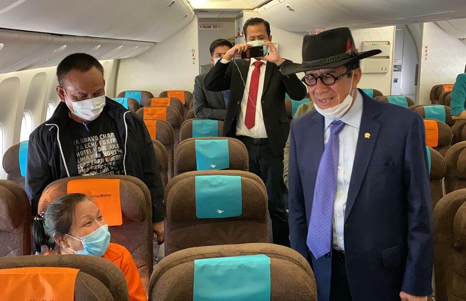 Graft fugitive Maria Pauline Lumowa, left, sits in a passenger plane as Justice MInister Yasonna Laoly stands next to her during a flight from Serbia to Indonesia on July 8, 2020. Maria was extradited 17 years after she was named a suspect. (Photo courtesy of the Justice Ministry)