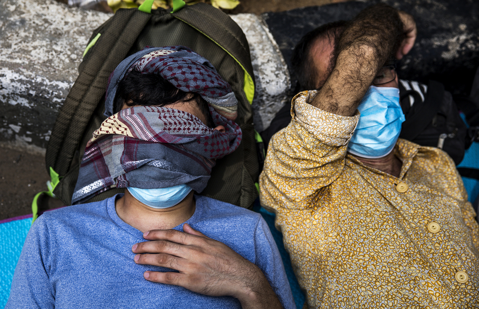 Two refugees sleep during protest in front of UNHCR office building in Kebon Sirih, Central Jakarta on Monday (13/07). (JG Photo/Yudha Baskoro)