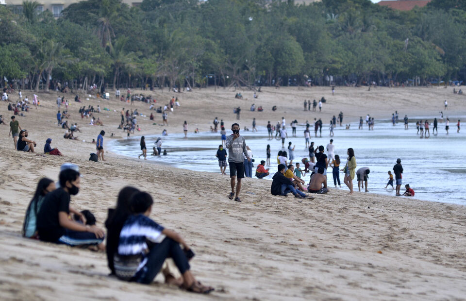 People enjoying the sight Kuta Beach, Badung, Bali after being reopened for local travelers. (Antara Photo/Fikri Yusuf) 