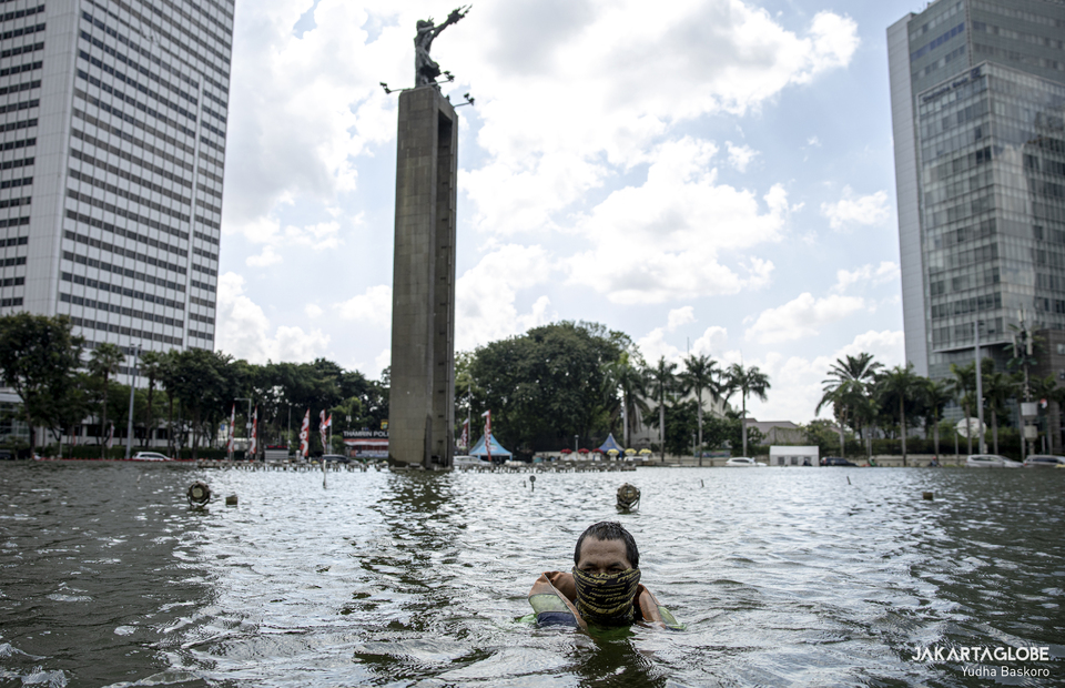 Budi wearing mask as he cleans the pool at Selamat Datang Monument in Central Jakarta on Friday (21/08). (JG Photo/Yudha Baskoro)