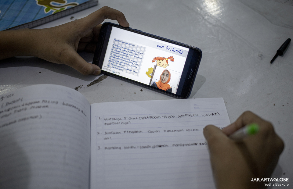 A teacher gives instruction from smart phone during long-distance learning at Citizens Hall in Galur, Johar Baru, Central Jakarta on Thursday (03/09). (JG Photo/Yudha Baskoro)