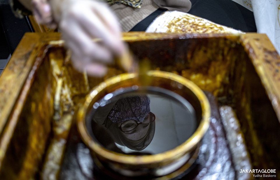A reflection of batik artisan in a bowl of wax in Rumah Batik Palbatu in Tebet, South Jakarta on Friday (02/10). (JG Photo/Yudha Baskoro)
