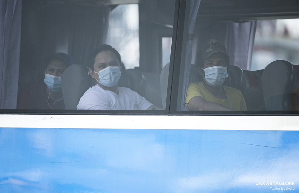 Crewmens sit inside a bus during evacuation process at JICT II Pier, Tanjung Priok Port, North Jakarta on Tuesday (06/10). (JG Photo/Yudha Baskoro)
