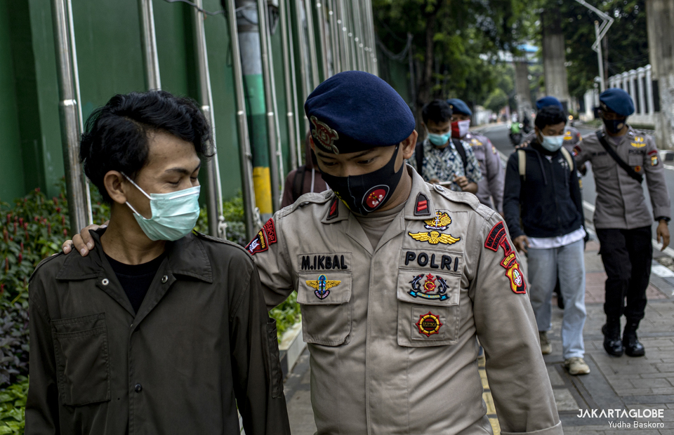 A police officer walks with a protesters at Perbakin building in Senayan, Central Jakarta on Wednesday (07/10). (JG Photo/Yudha Baskoro)