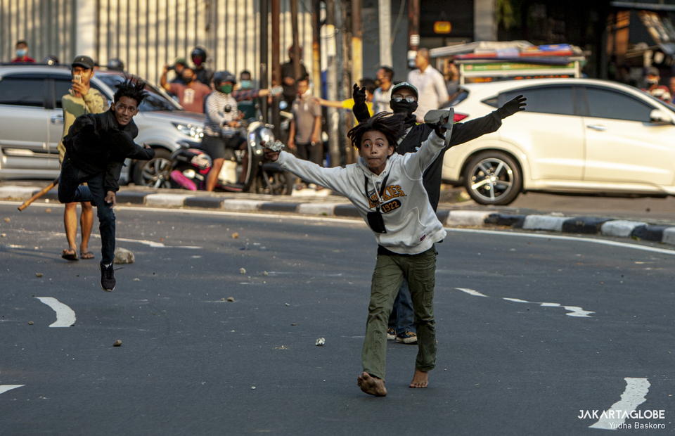 A man carries a stone during riot in Jalan Pejompongan Raya, Palmerah, West Jakarta on (07/10). (JG Photo/Yudha Baskoro)