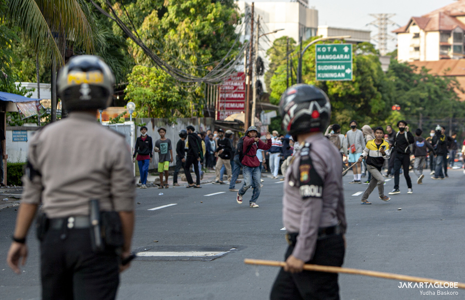 Police personnels using a bamboo stick fight rioters in Jalan Pejompongan Raya, Palmerah, West Jakarta on (07/10). (JG Photo/Yudha Baskoro)