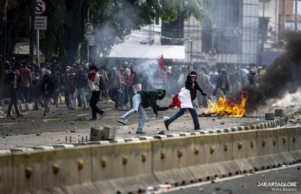 Protesters throw stones and bottles to police barricade during riot in Harmoni, Central Jakarta on Thursday (08/10). (JG Photo/Yudha Baskoro)