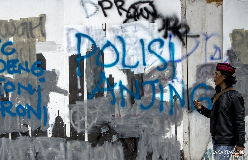 Protesters scribbled Polisi Anjing on the walls during the protests during riot in Arjuna Wiwaha Horse Statue in Central Jakarta on Tuesday (13/10). (JG Photo/Yudha Baskoro)