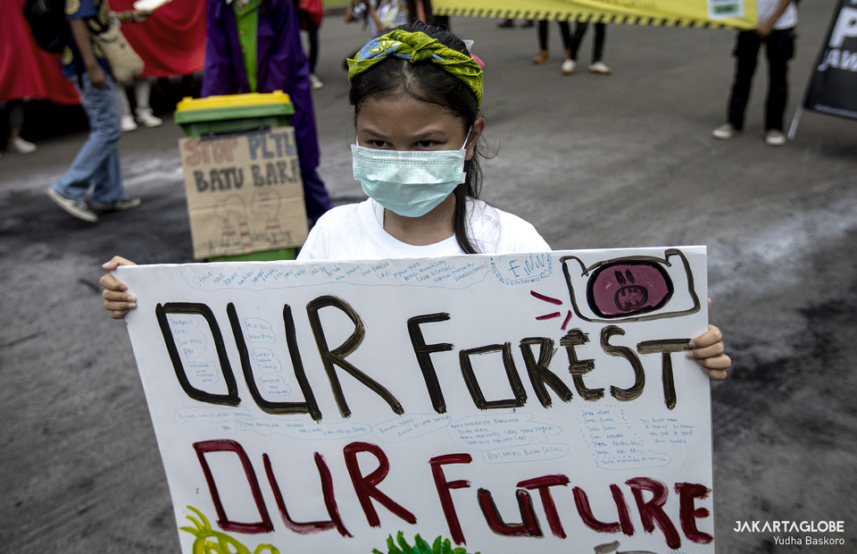 A child carries a placard that reads our forest our future during long march againts climate crisis in front of ESDM building in Central Jakarta on Friday (27/11). (JG Photo/Yudha Baskoro)